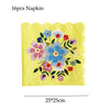 A yellow napkin featuring a colorful floral pattern with blue, pink, and red flowers.