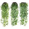 Three strands of artificial green plant vines hanging vertically