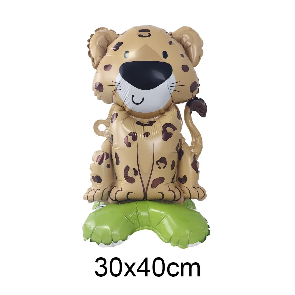 A foil balloon shaped like a leopard or cheetah head with brown and black spots, sitting on a green balloon base.