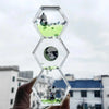 A clear hexagonal hourglass timer filled with green liquid and featuring a panda figure.