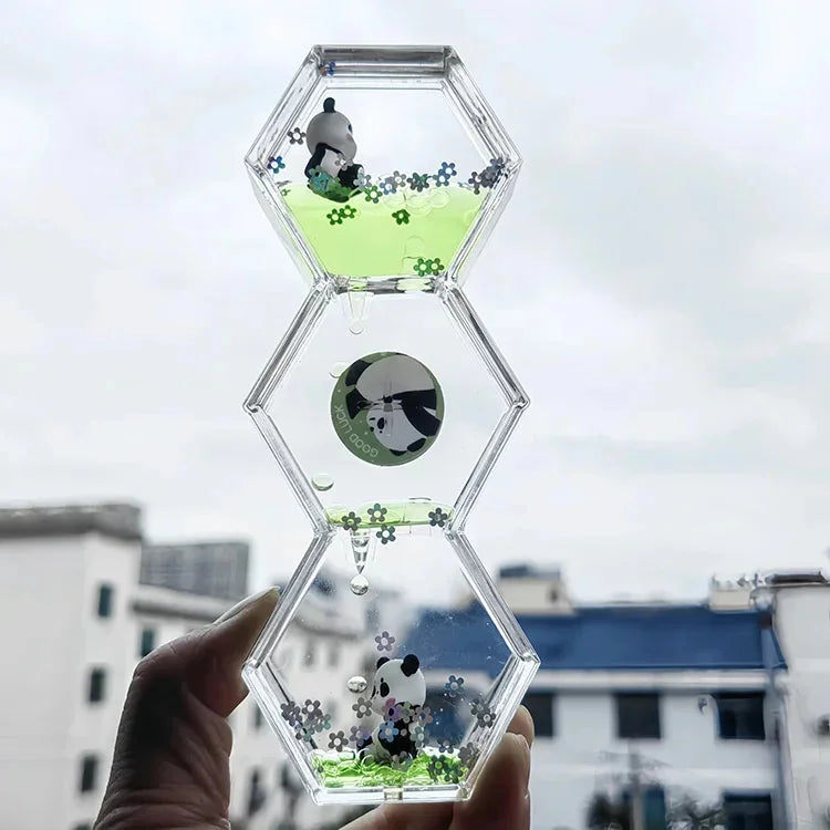 A clear hexagonal hourglass timer filled with green liquid and featuring a panda figure.