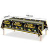 A long black table decorated with construction vehicle graphics for a birthday party.