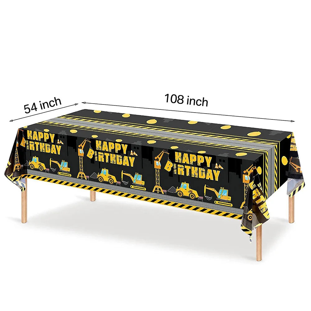 A long black table decorated with construction vehicle graphics for a birthday party.