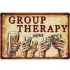 A vintage metal tin sign with the text GROUP THERAPY HERE, featuring hands holding various glasses.