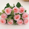 A bouquet of pink artificial roses with green leaves and stems.