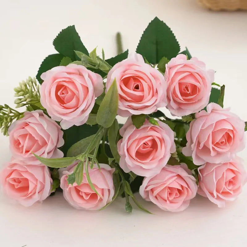 A bouquet of pink artificial roses with green leaves and stems.