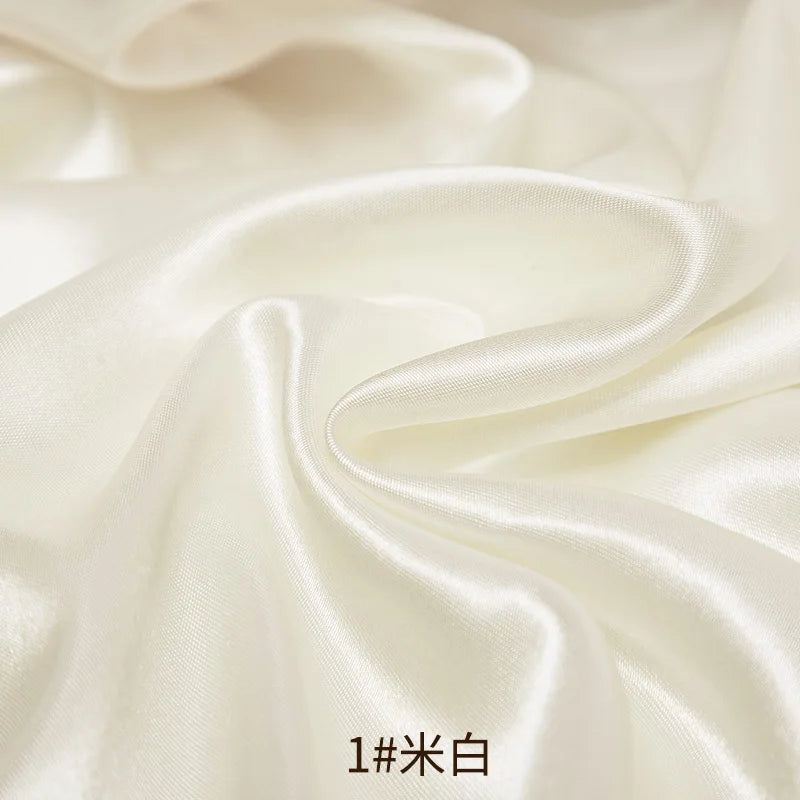 Cream satin fabric draped in soft folds for sewing and DIY projects
