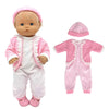 A baby doll outfit set including a pink hat, white onesie, and matching pink cardigan and pants.