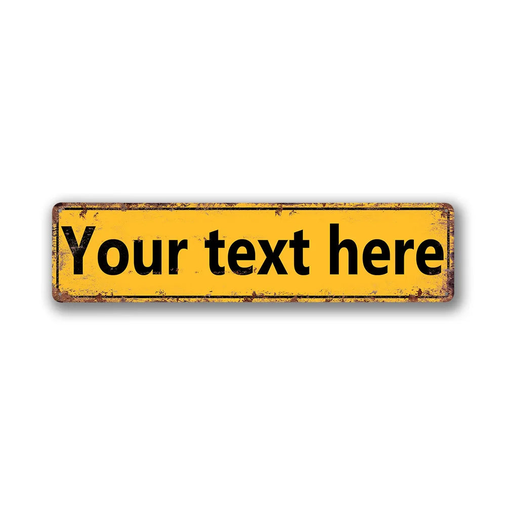 A rectangular vintage tin sign with distressed yellow paint and black text that reads Your text here.