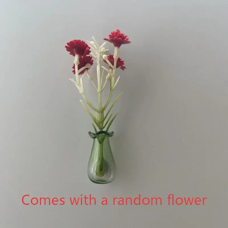 A glass vase holds a stem of pink and white flowers, used for fridge decor.