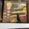 A black obsidian crow statue is displayed on a shelf among books.