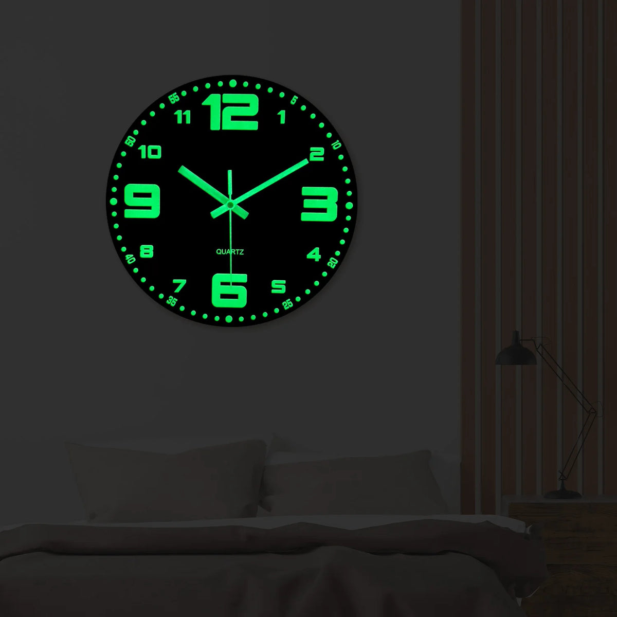 A round green glow-in-the-dark digital clock face with black background and glowing green hands mounted on a wall.
