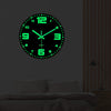 A round green glow-in-the-dark digital clock face with black background and glowing green hands mounted on a wall.