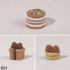 A set of three round, stacked cake toppers in brown and white frosting with colorful sprinkles.