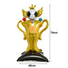 A gold trophy shaped like a soccer ball stands on a black base, used as football-themed party décor.