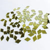 A scattered pile of small, square gold-colored mirror tiles used for 3D mosaic wall decals.