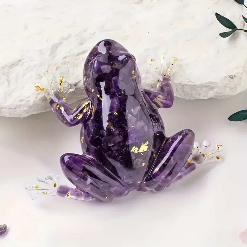 A purple crystal frog resin craft decoration lying on a white surface.