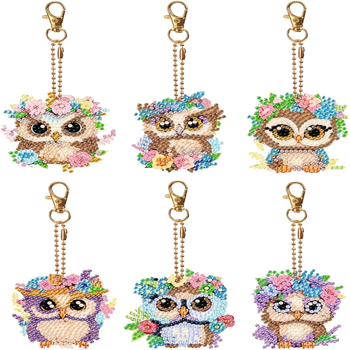 A set of DIY diamond painting owl keychains featuring colorful feathers and detailed eyes.