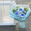 A bouquet of handmade crochet flowers in blue and purple hues with a handwritten message