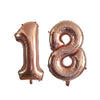 Two metallic rose gold foil number balloons, 1 and 8, for a birthday party.