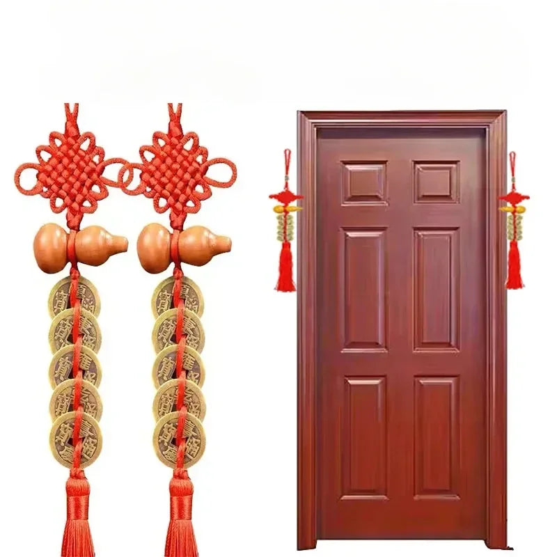 Traditional Chinese knot pendant featuring a red thread, wooden gourd, and copper coins hanging on a dark brown wooden door.