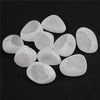 A collection of tumbled natural crystals including clear quartz, rose quartz, and amethyst in egg shapes.