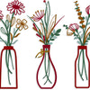 A set of three rustic metal flower vases with dried flowers and greenery.
