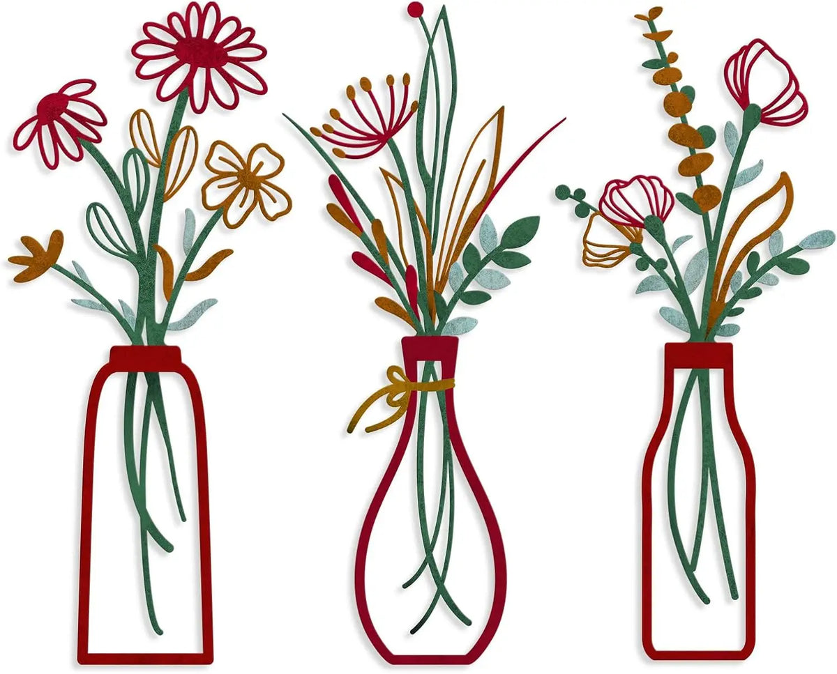 A set of three rustic metal flower vases with dried flowers and greenery.