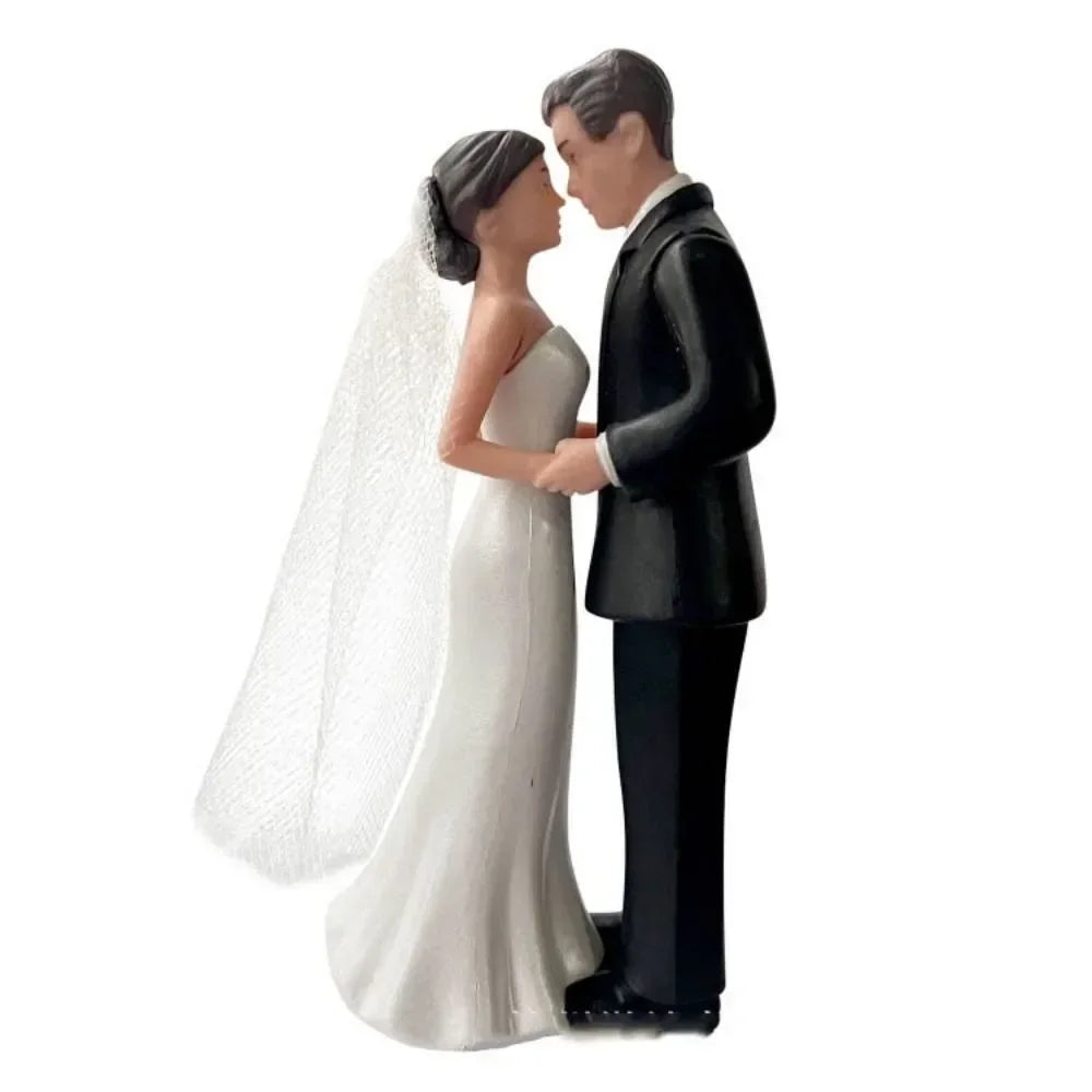 A bride and groom cake topper featuring a couple embracing in a romantic pose.