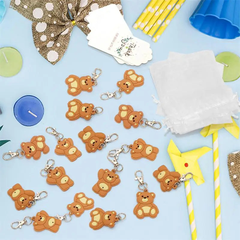 A collection of cute bear keychain party favors with organza bags and thank you tags