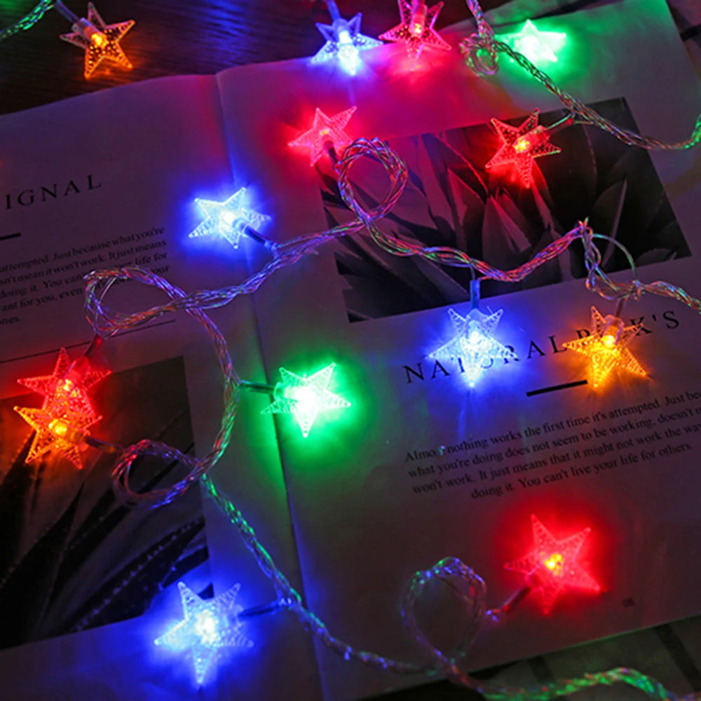 A close-up of LED star fairy lights illuminating a dark background, displayed on an open book page.