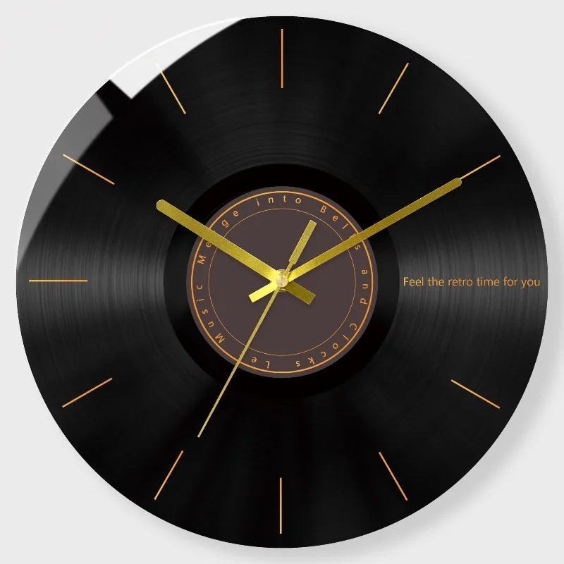 A black vinyl record style wall clock with a gold-colored face and hands.