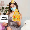 A woman holds an orange birthday cake with candles and a gift box decorated for an 18th birthday.