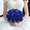 A bouquet of deep blue glitter artificial roses held by a person in a white top.