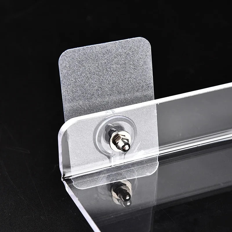 Clear acrylic floating shelf with a wall mount attached to a dark surface.
