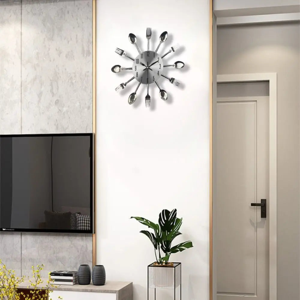 A modern cutlery 3D wall clock with silver utensils mounted on a white wall above a television and plant.
