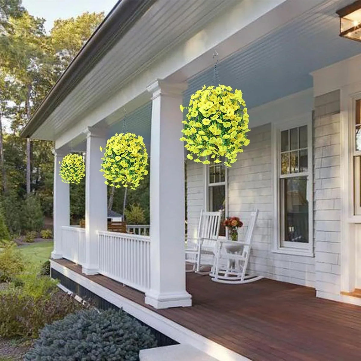 A yellow artificial morning glory and eucalyptus garland hanging in a porch setting.