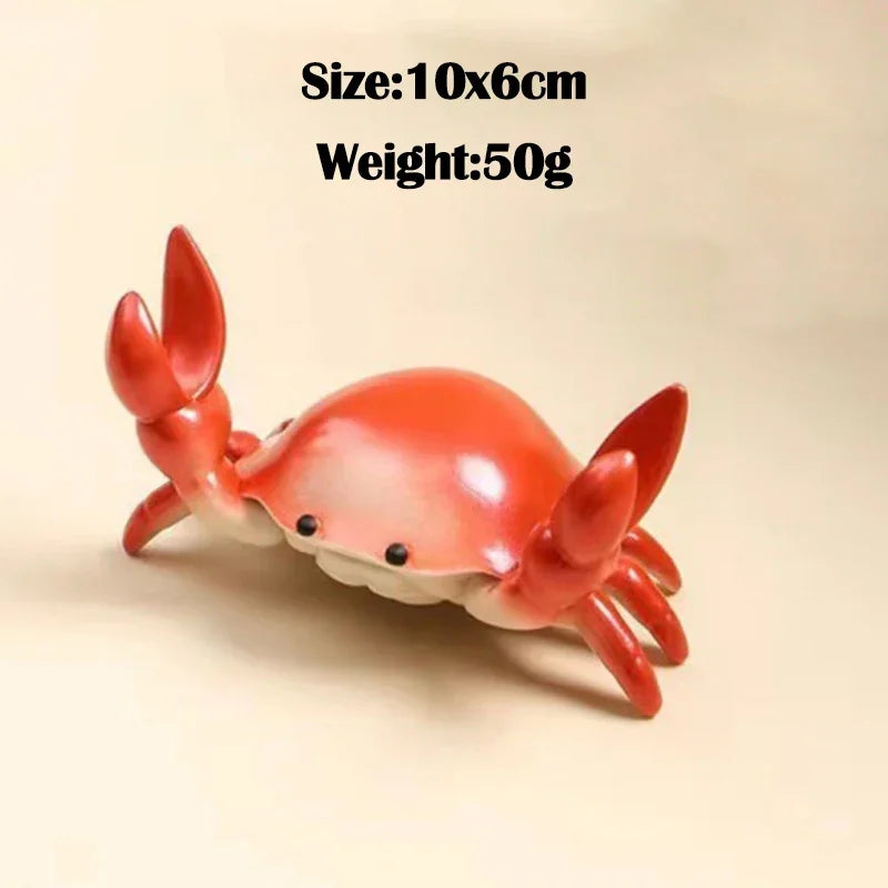A bright red crab-shaped desk organizer with slots for a pen and phone.
