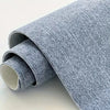A roll of gray self-adhesive runner rug material is shown, partially unrolled.