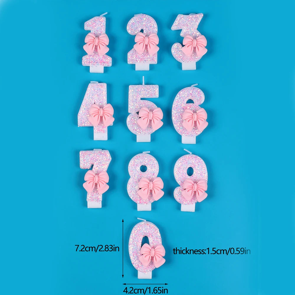 A set of glitter number cake candles from 1 to 8, each featuring a pink bow on a white base.