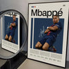 A framed poster featuring a signed photo of Mbappé in a blue jersey and shorts against a dark background.