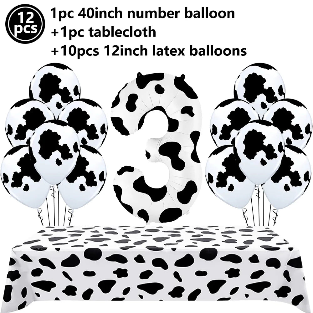 A set of cow print number balloons and a tablecloth for a farm-themed birthday party decoration.