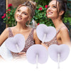 Two women smiling while holding heart-shaped white paper folding fans