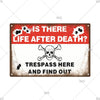 Vintage metal warning sign with skull graphics and text asking Is there life after death? and Trespass here and find out