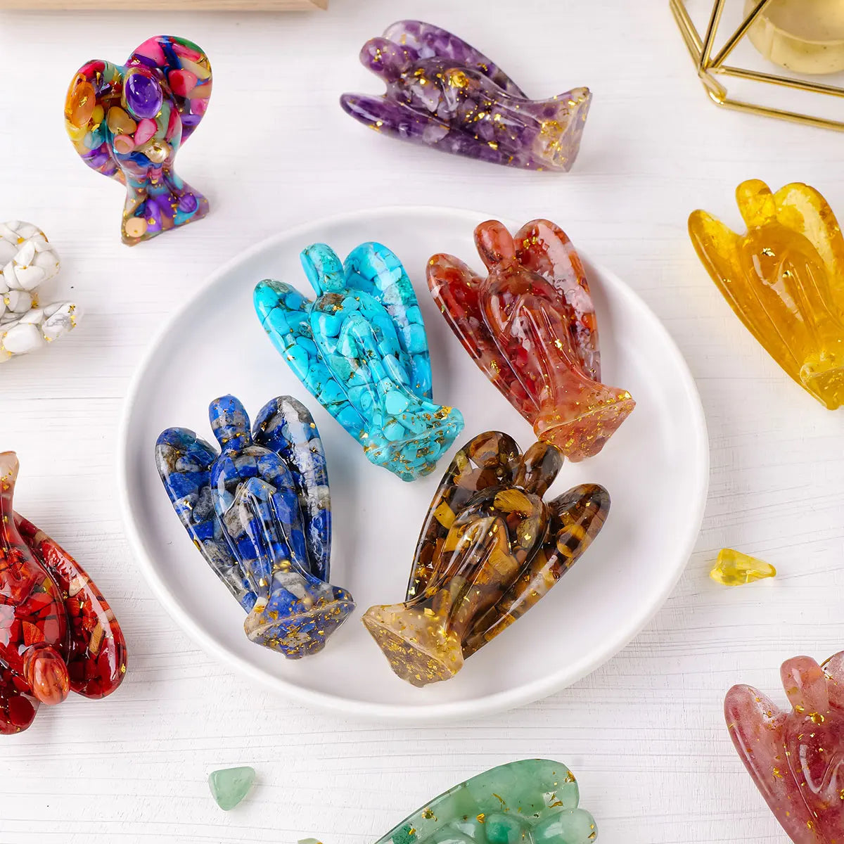 A collection of natural crystal guardian angel figurines in various colors and shapes displayed on a white surface.