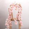 A wooden chair decorated with a lush pink artificial sakura flower garland.