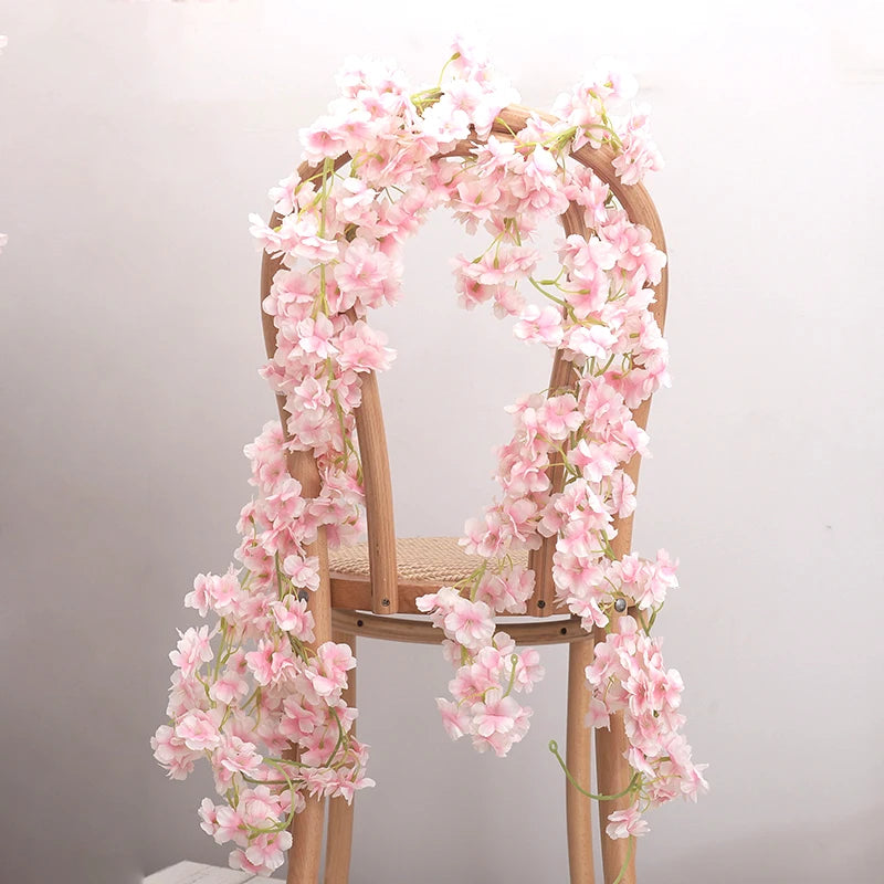 A wooden chair decorated with a lush pink artificial sakura flower garland.