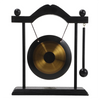 A black and brass gong decor set featuring a large circular gong suspended by a stand.