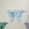Light blue decorative bow-shaped wooden wall shelf mounted on a white wall.