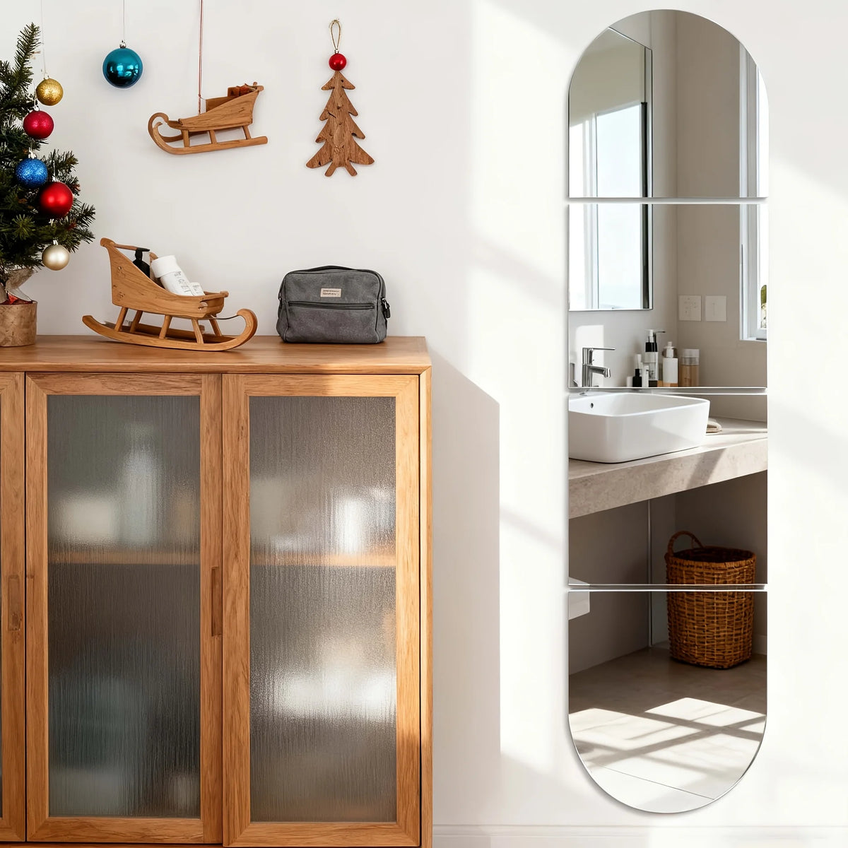 A wooden shelf displays a mirror and decorative items, including a Christmas tree, wooden sleighs, and a leather bag.